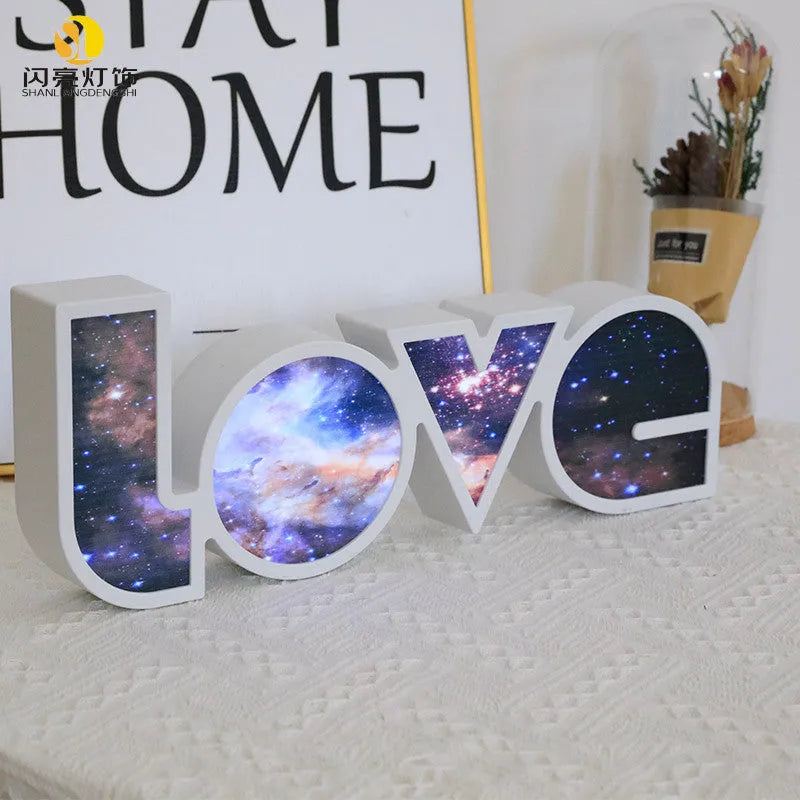 Rainbow colour LED LOVE light decoration for Valentine's Day or weddings on a desk.