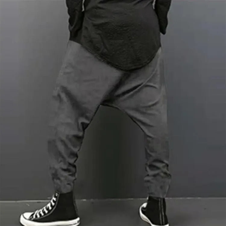 Cotton loose harem pants in black with elastic waist, side view on model