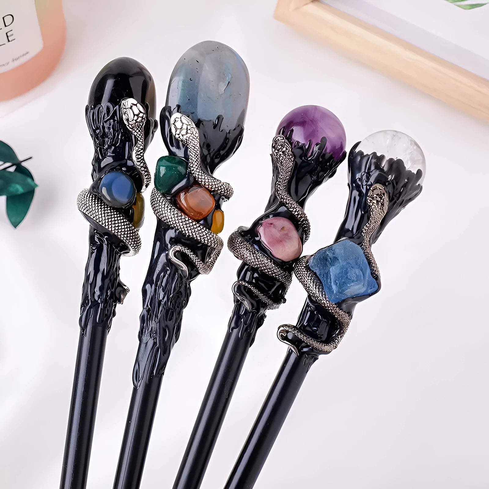 Natural crystal magic wand with labradorite stone ball on simple handle against neutral background