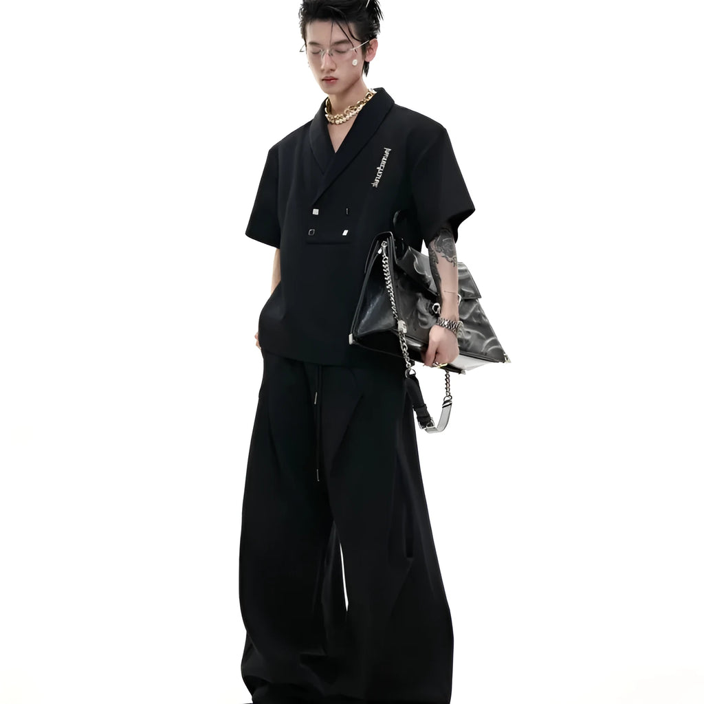 Men's dark grey V-neck sports suit with padded shoulders, metal details, and cotton shorts laid flat.