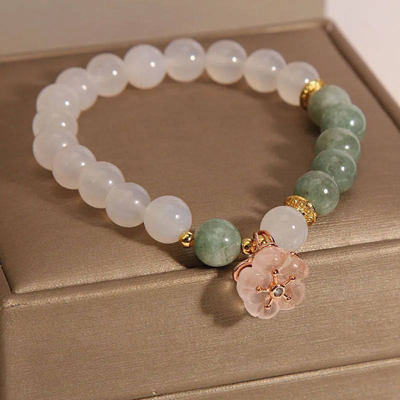 White agate jade bracelet with floral shape on a casual model wrist.