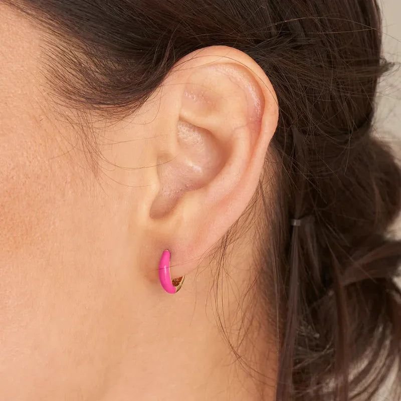 A pair of oval-shaped epoxy resin earrings on a U-shaped curved silver hook, showing a marbled colour finish.