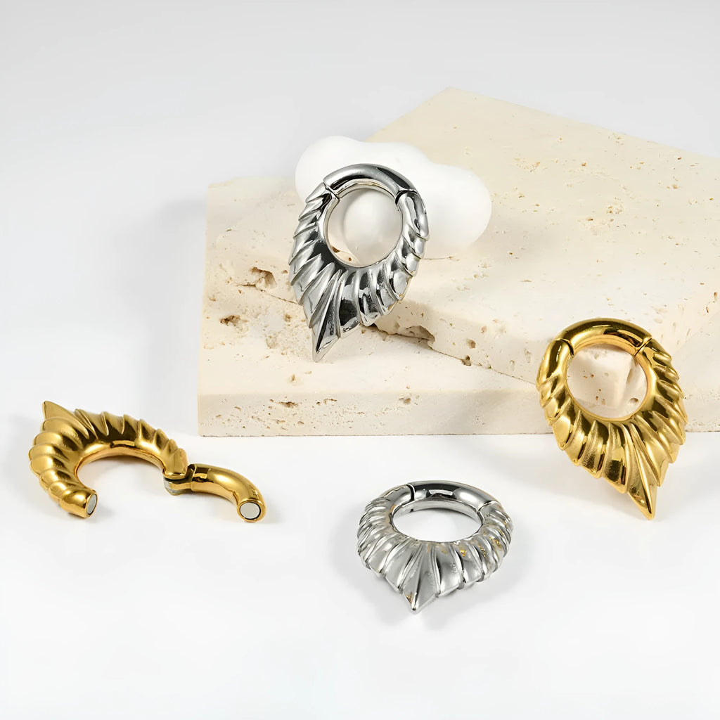 A stainless steel drop-shaped ear extender with totem detailing for 0 gauge stretched earlobes.