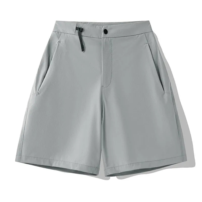 Man wearing khaki 3D cut athletic shorts with four-way stretch, suitable for running or climbing.