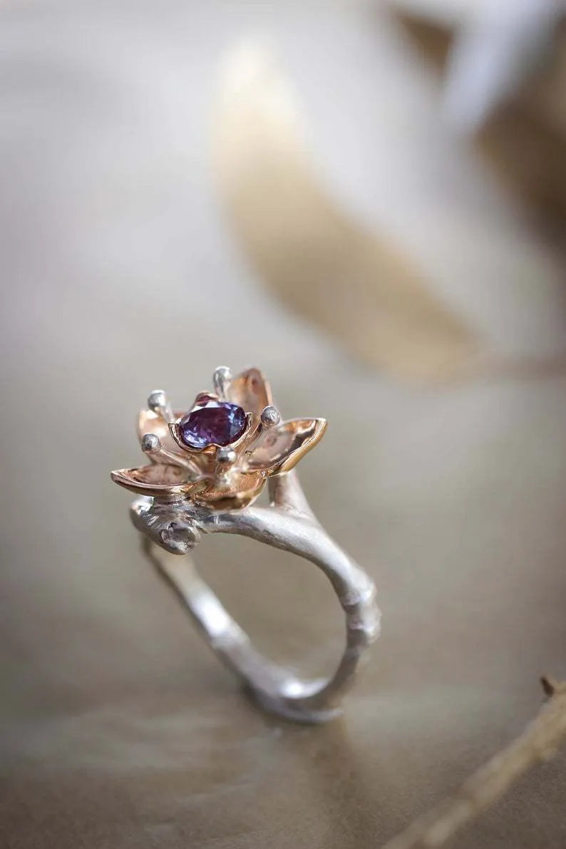Silver two-tone alloy ring with a geometric floral pattern on a model's hand.