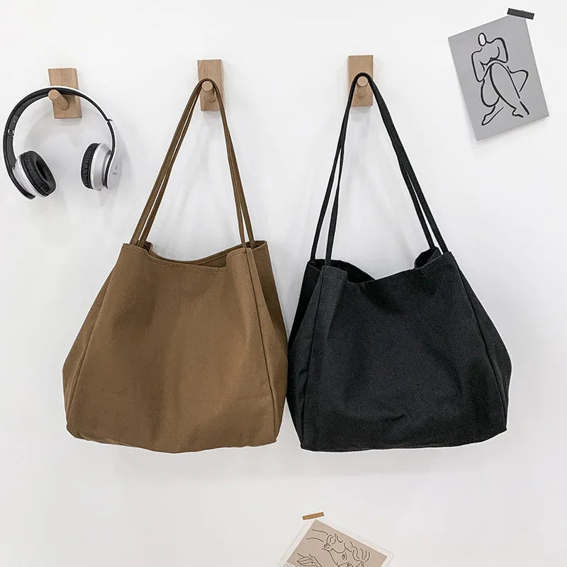 Women's solid colour canvas handbag showing horizontal square shape with double shoulder straps