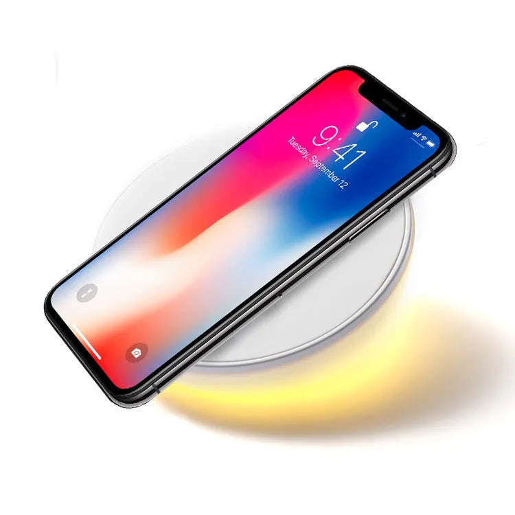 White wireless charging pad with LED clock display showing time, three control buttons, and Qi charging surface for smartphones