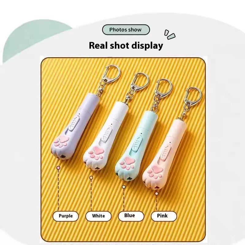 Cream white plastic cat teaser wand with laser light and attached fabric catnip pouch on a table.