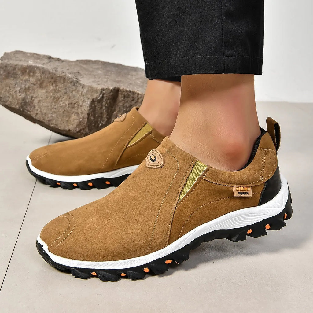 A pair of grey round-toe men's slip-on shoe covers made of PU with a rubber sole.