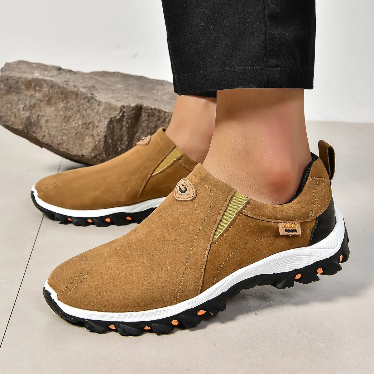 A pair of grey round-toe men's slip-on shoe covers made of PU with a rubber sole.