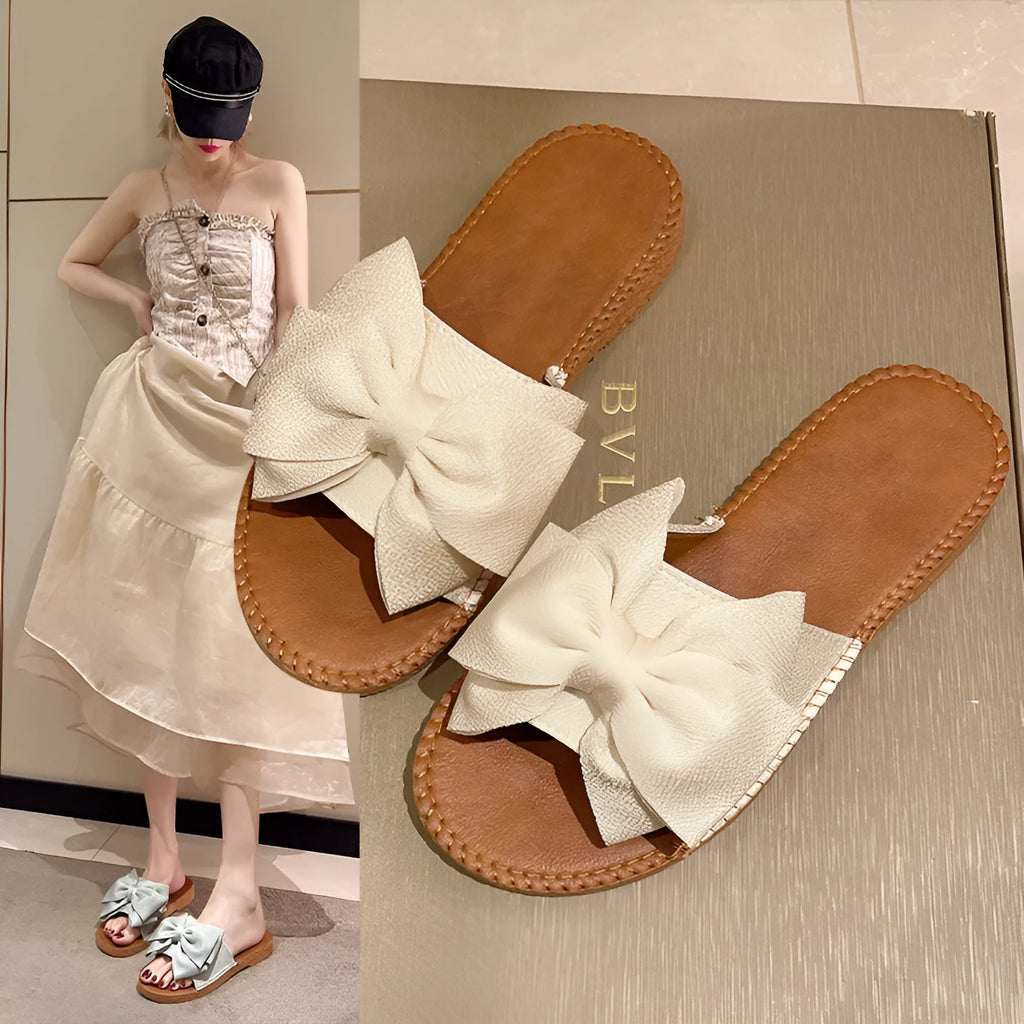 Women's beige slip-on sandals with bow detail and flat rubber sole