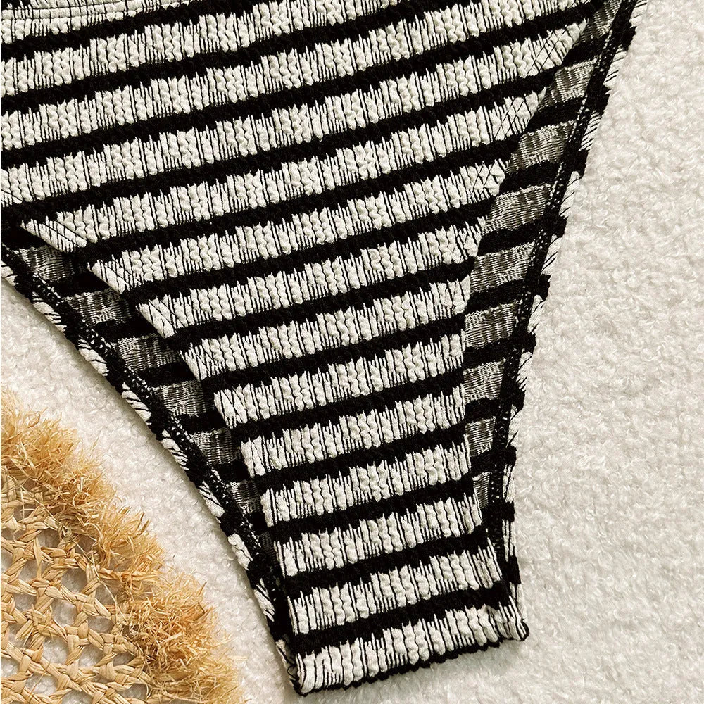 Women's pink and black striped bikini swimsuit with solid briefs.