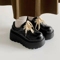 Matte black women's lace-up heels with a thick sole and round toe.