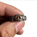 Close-up of a hand-forged copper Grotto Buddha ring with a rock texture surface.