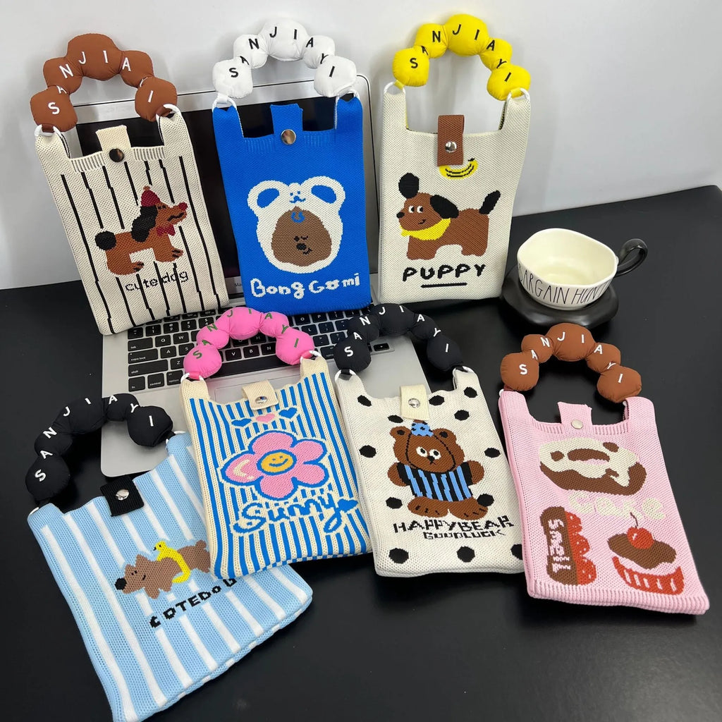 Cartoon knitted messenger bag with square vertical shape and character design showing open pocket and shoulder strap