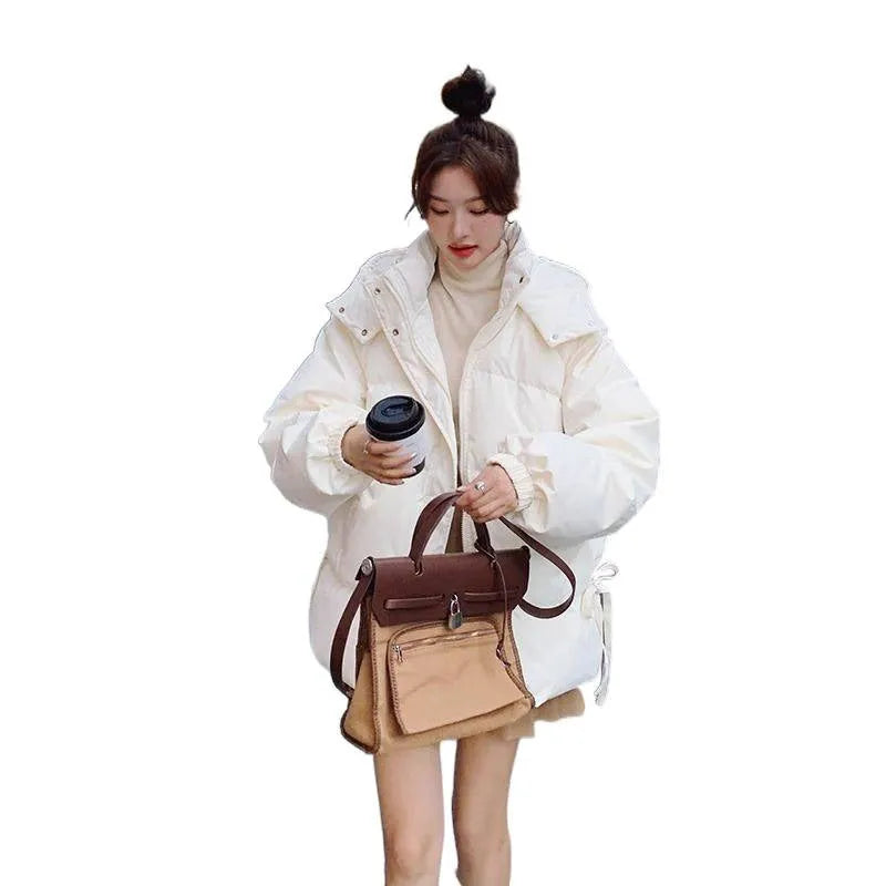 Women's loose black winter jacket with princess sleeves on a hanger.