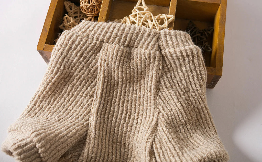 Brown cloth dog pullover sweater on a small white dog, showing casual style.