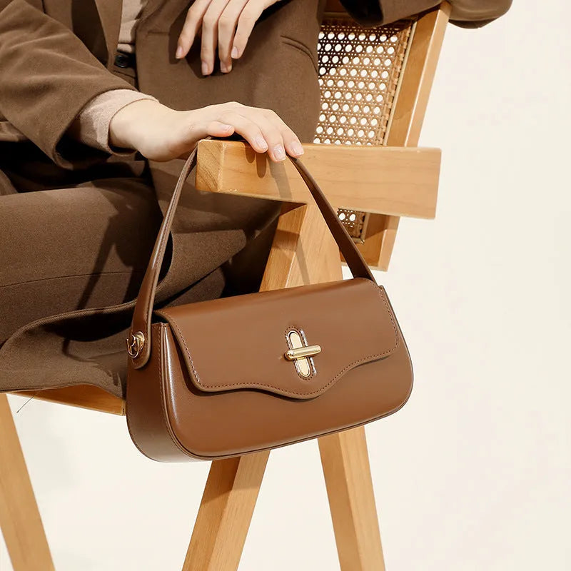Genuine leather women's baguette handbag with lock detail and double shoulder straps