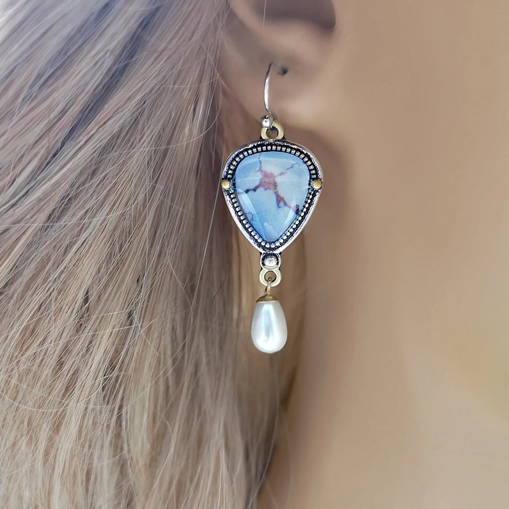 Retro blue drop earrings with synthetic blue opal and white pearl on a geometric metal setting.