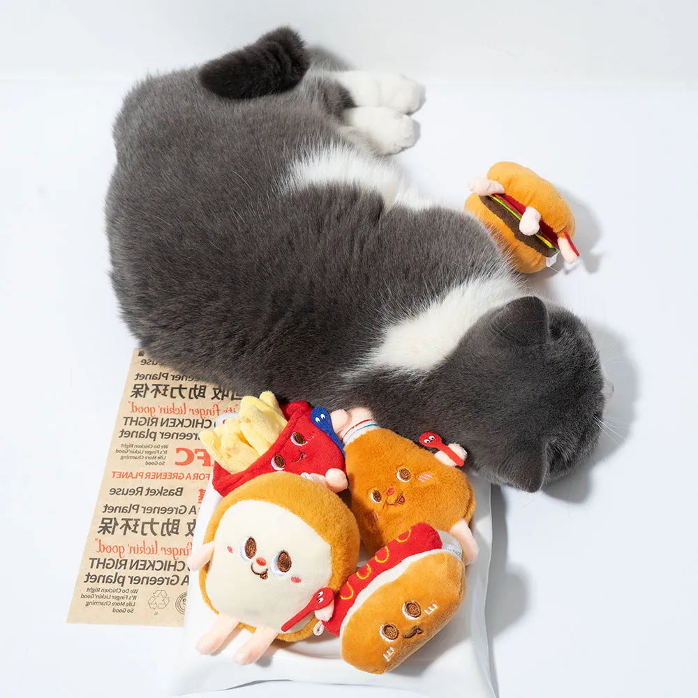 Five cat teething toys shaped like hamburger, chicken leg, fries, hot dog and bread on white background