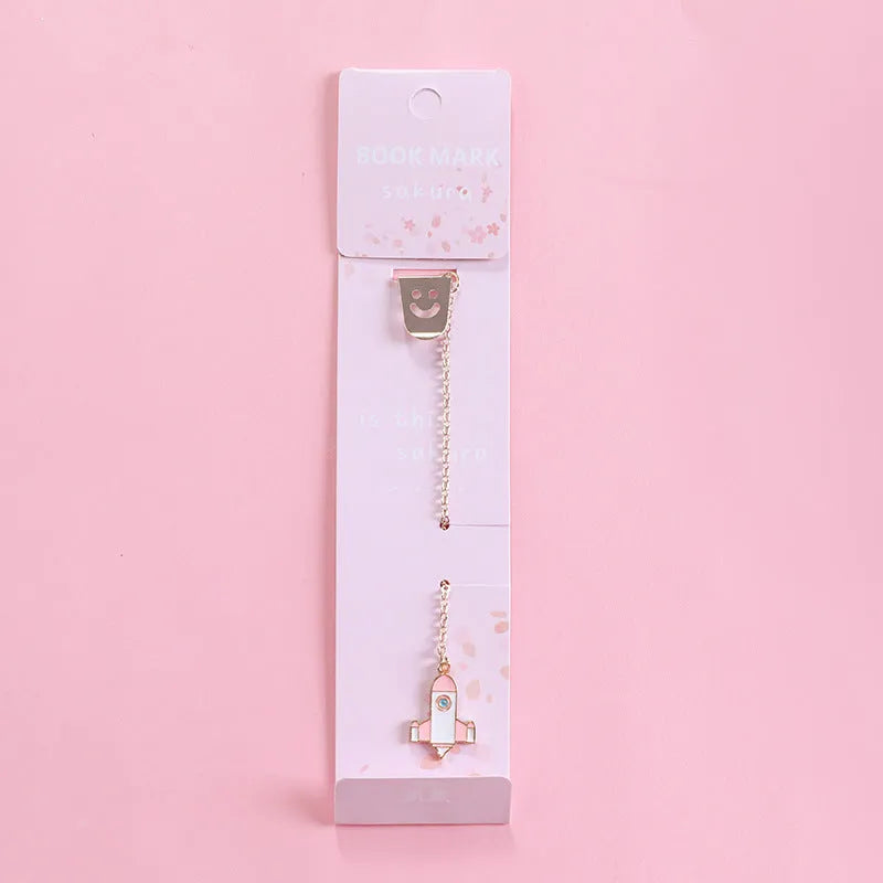 Cartoon-themed alloy metal bookmark charm on a book page.