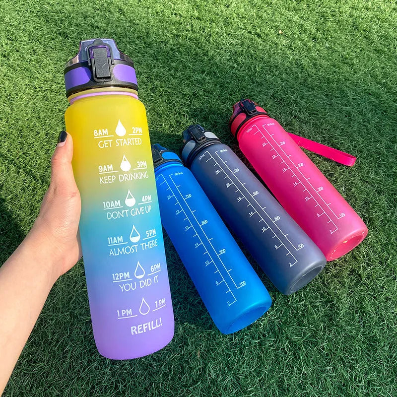 Blue and red gradient 1-litre Tritan sports water bottle with time markers, flip-top lid, and wrist strap.