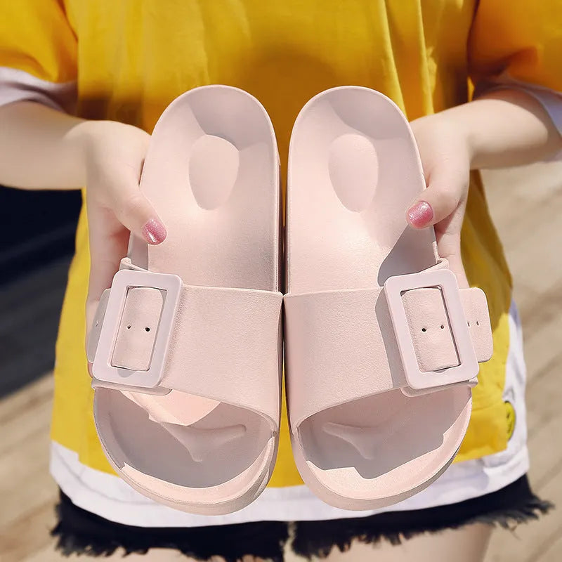 Women's grey blue EVA flip-flop sandals with a silver buckle on the strap, showing flat sole.