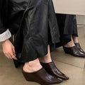 Women's black closed toe wedge half slippers showing PU upper material and wind wedge sole design