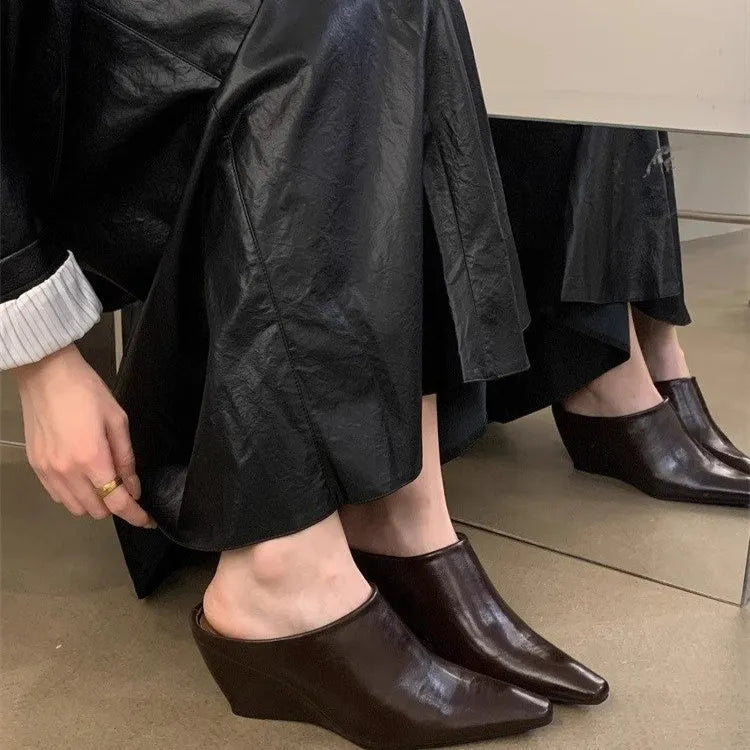 Women's black closed toe wedge half slippers showing PU upper material and wind wedge sole design