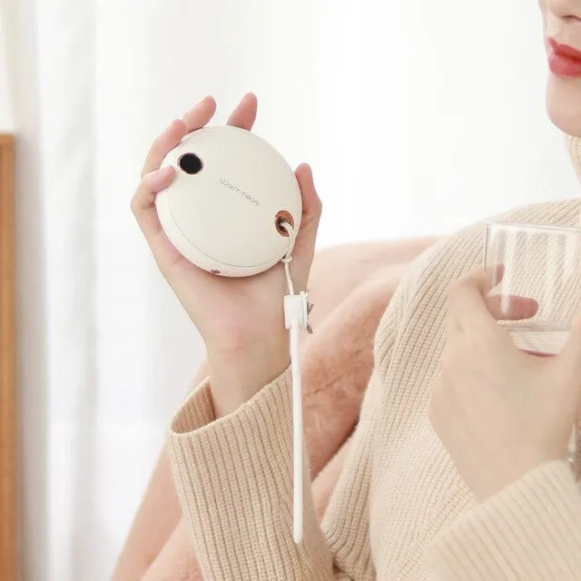Green 5000mAh power bank hand warmer with digital display shown next to its charging cable.