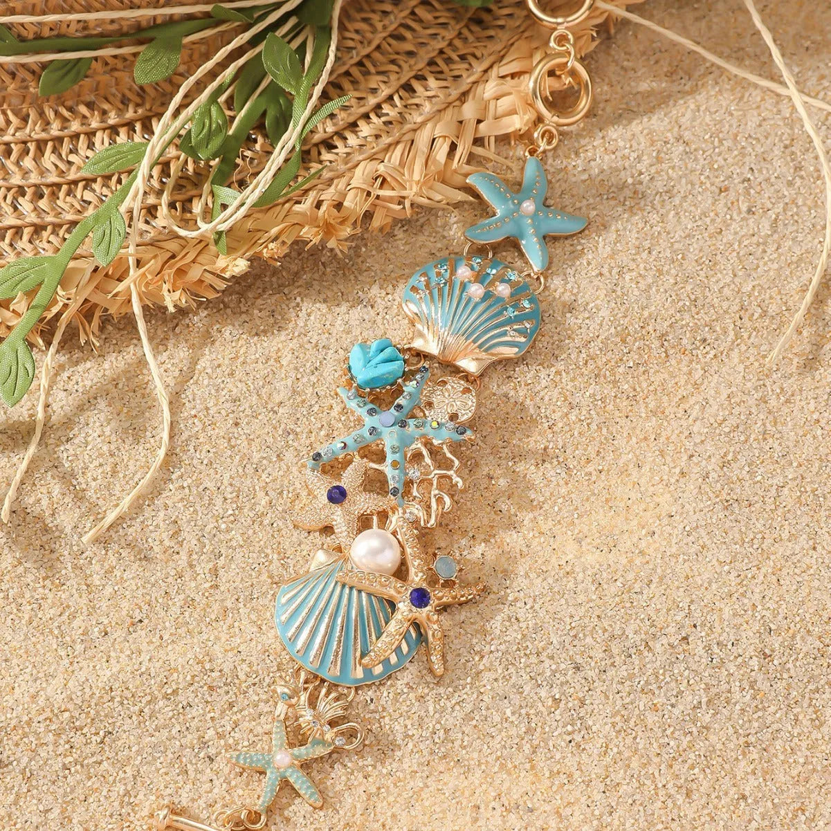 Alloy rhinestone bracelet with boat anchor, shell, and starfish charms in turquoise, red, or blue.