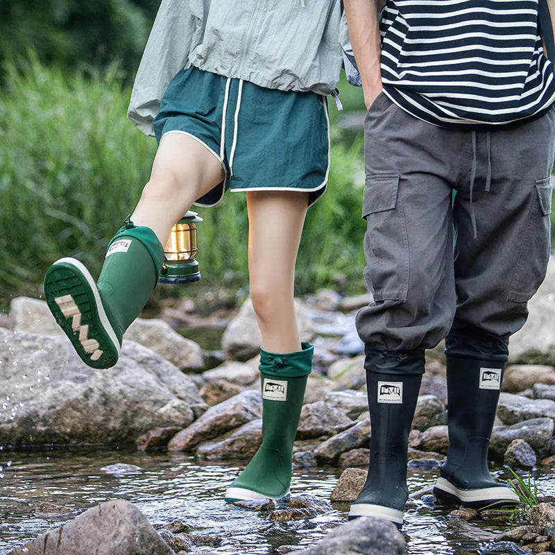 A pair of high tube PVC rain boots in a solid colour, shown on a size label with a non-slip sole.