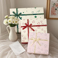 Cardboard gift box with bow in red, green, and pink, multiple sizes for gifts