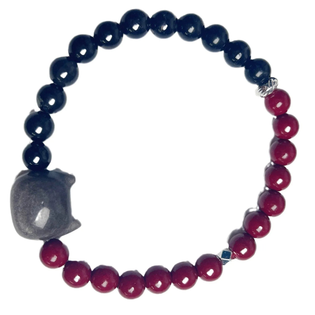 Obsidian crystal cat bracelet with colourful woven string band on a wrist.