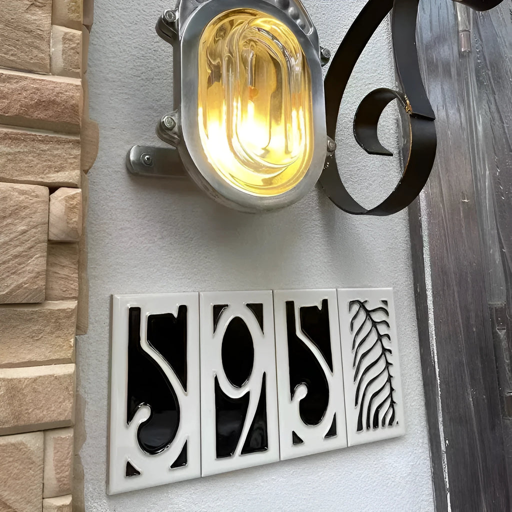 Handmade retro-style ceramic doorplate with fired enamel number, shown against a door.