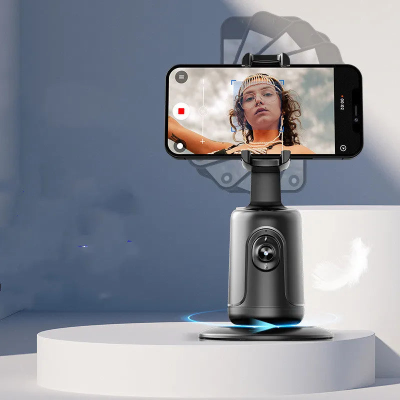 Automatic tracking stabiliser with 360-degree rotation in black, pink, and white on a desktop