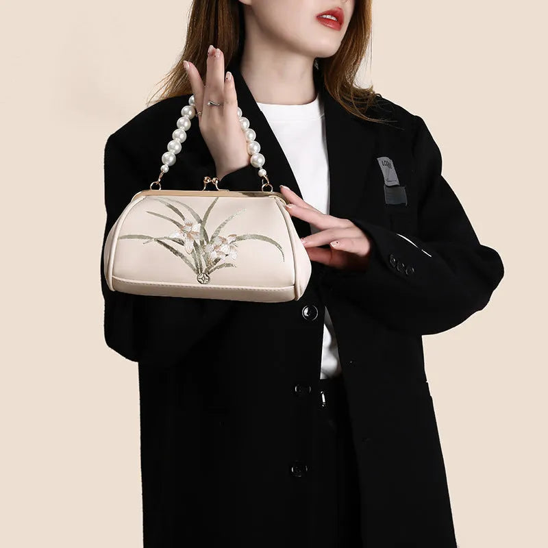 Beige women's embroidered shoulder bag with shell shape design made from soft PU leather