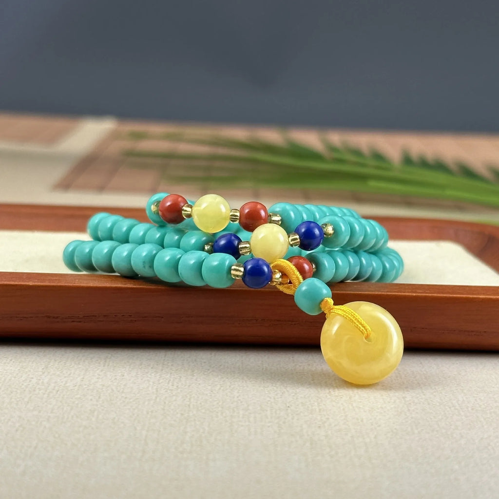 Turquoise mesh flower lucky pendant on a ball bead chain necklace, showing clasp.