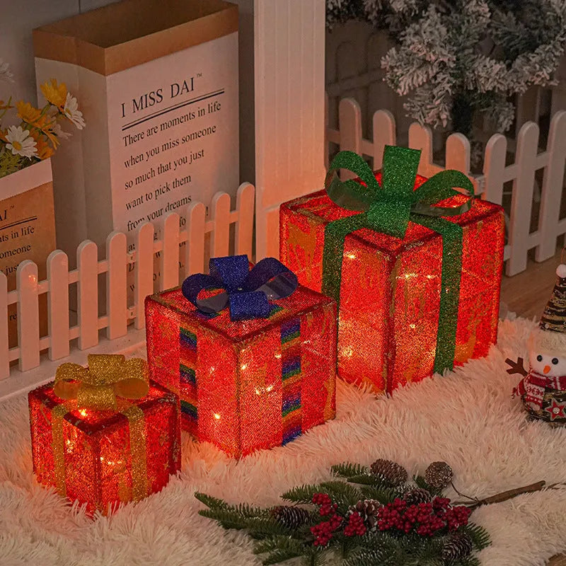 Set of three lighted Christmas gift box decorations with bows for outdoor holiday decor