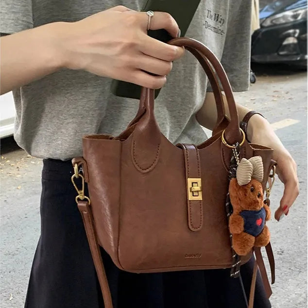 Small Korean-style PU bucket tote bag with outer pocket in apricot, showing sewing thread detail