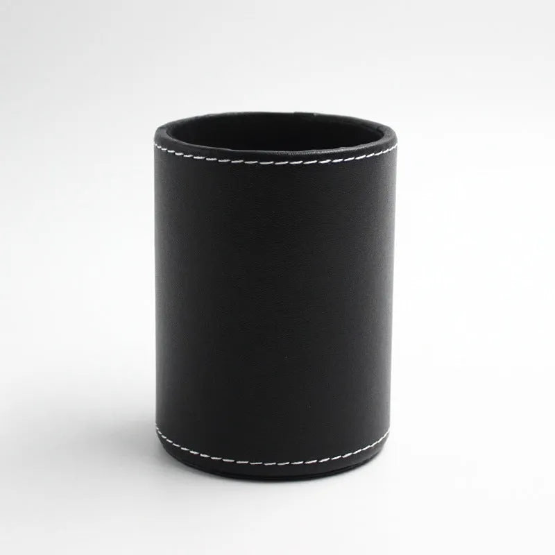 Small round black leather pen container for desk organisation.