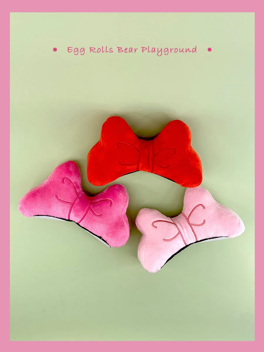 Soft plush bow tie helmet decoration in red, peach pink, or rose pink for motorcycle and ski helmets.
