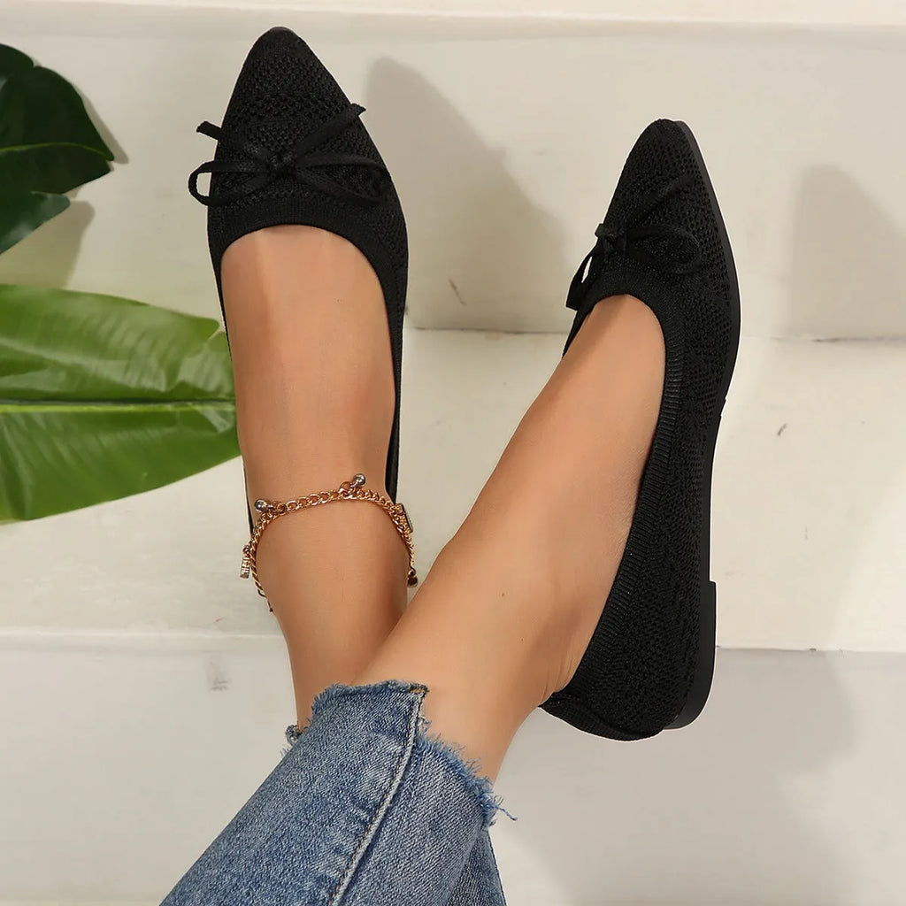 Women's blue knitted flat loafers with a pointed toe and a decorative bow on the front