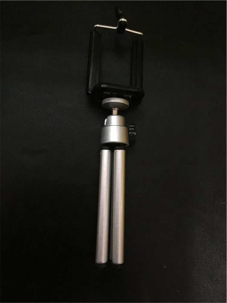 Black adjustable desktop phone holder with two-section metal bracket on a wooden desk