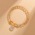 Gold rutilated quartz crystal bracelet with geometric design and safety buckle