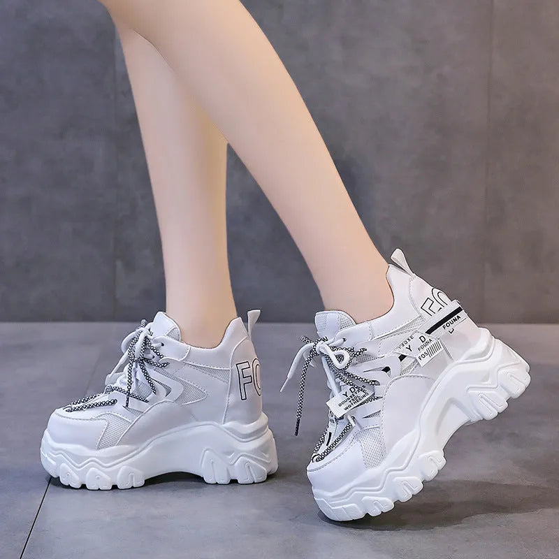 Women's white and black mesh platform sports shoes with a cross strap and a thick rubber sole.