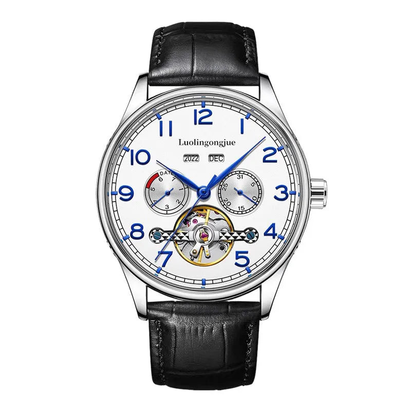 Men's stainless steel mechanical watch with leather strap and butterfly buckle on a business suit cuff.