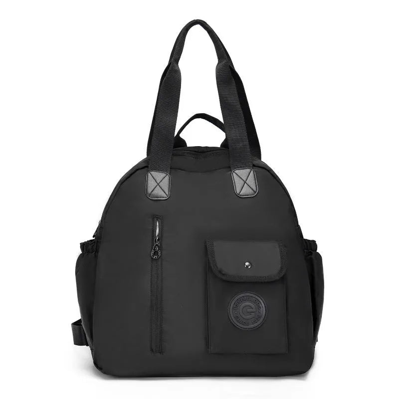 Large black nylon backpack with a front sandwich pocket, shown next to a khaki and a green graphic version.