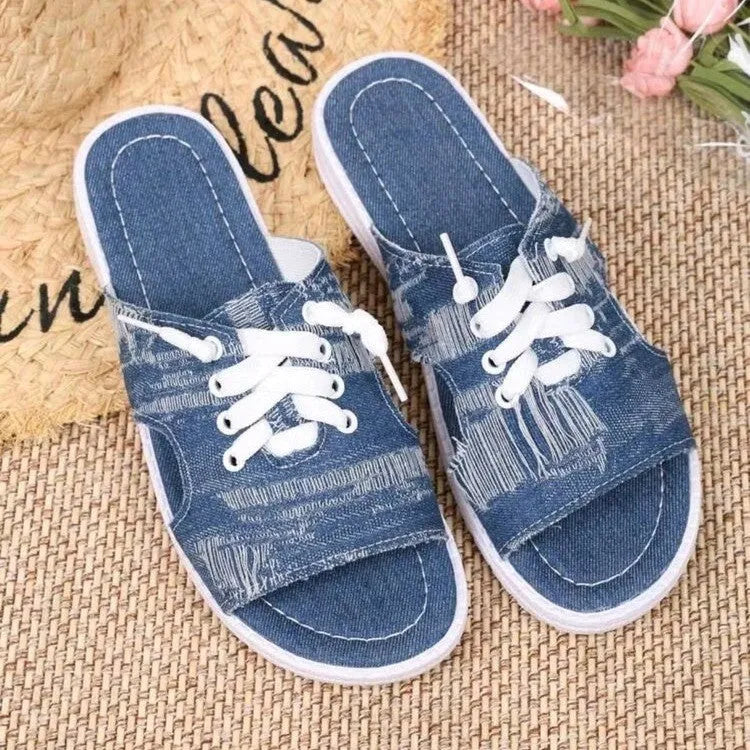 Blue Roman-style canvas slippers with cloth lining and rubber sole showing flat design