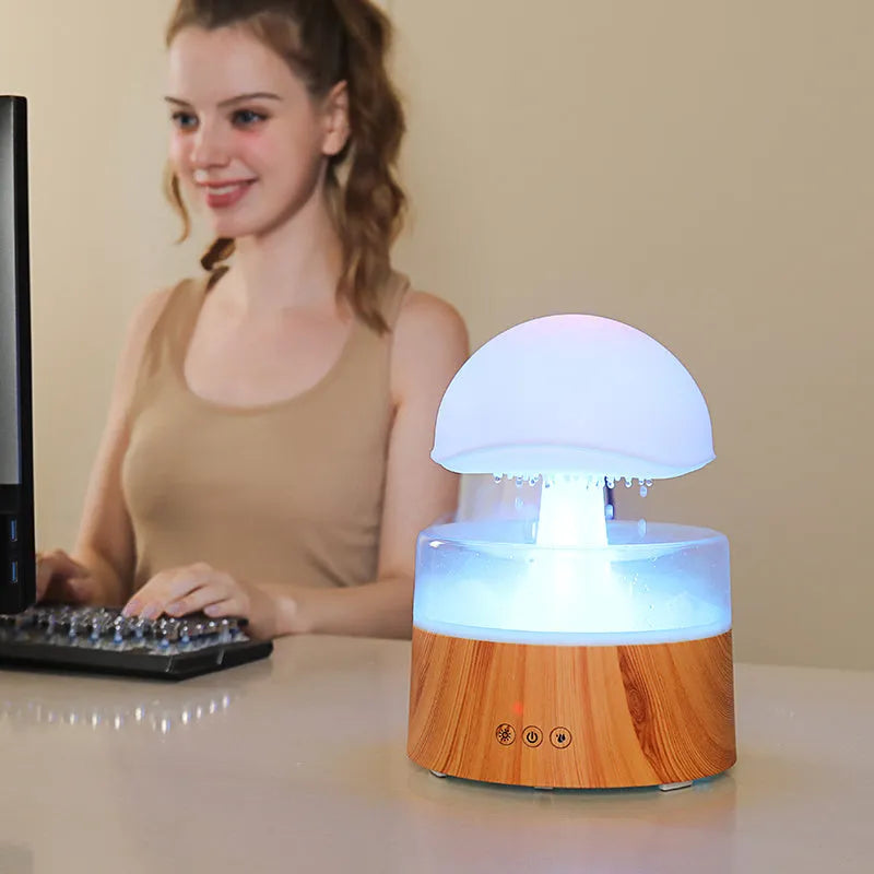White cloud-shaped humidifier and aroma diffuser with coloured lights and simulated rain.
